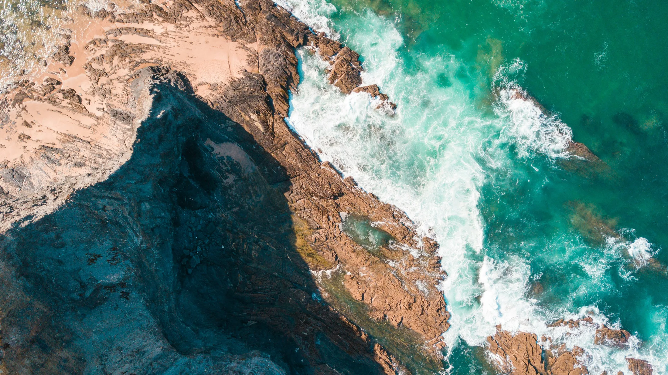 Vista aérea de una costa rocosa del Atlántico y aguas oceánicas cristalinas